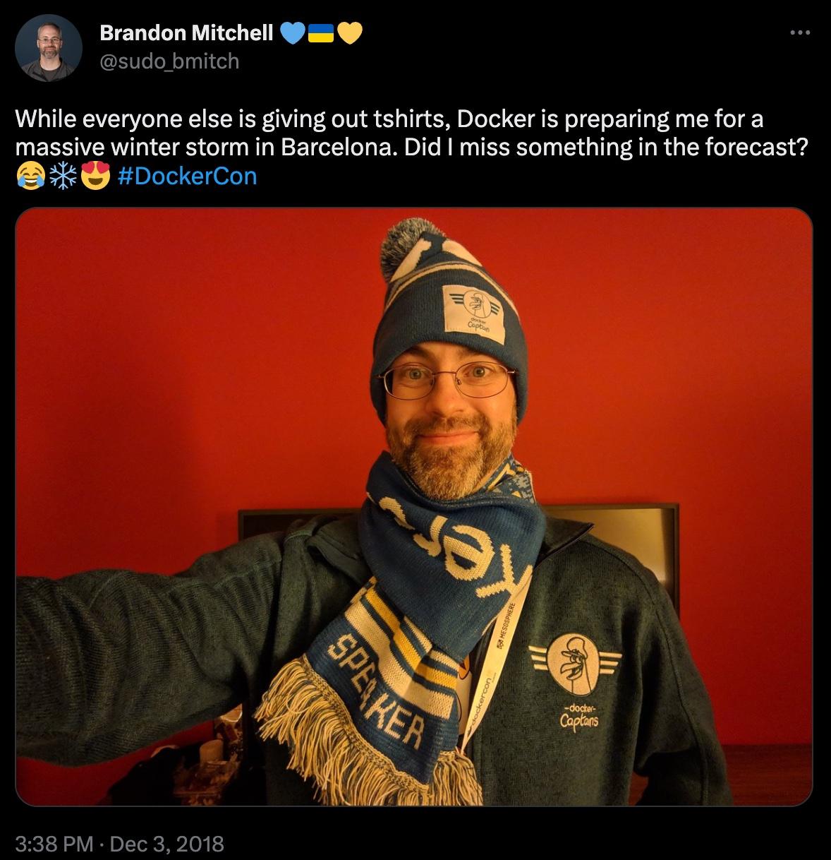 Twitter screenshot of Brandon Mitchell bundled up with Docker swag. Caption reads, "While everyone else is giving out tshirts, Docker is preparing me for a massive winter storm in Barcelona. Did I miss something in the forecast?"